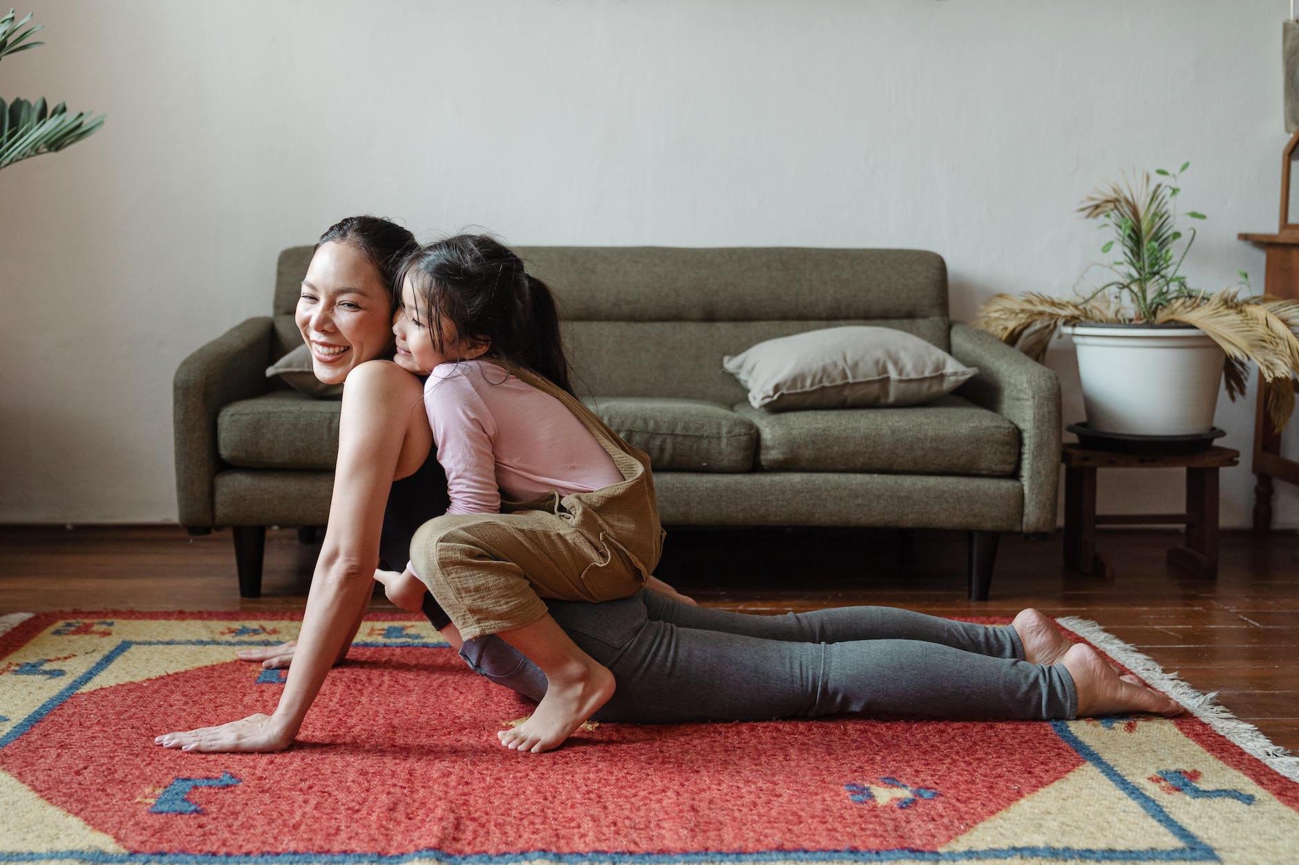 photo of girl hugging her mom while doing yoga pose