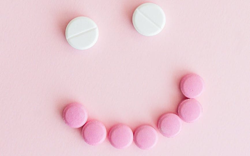 medicine tablets on pink surface